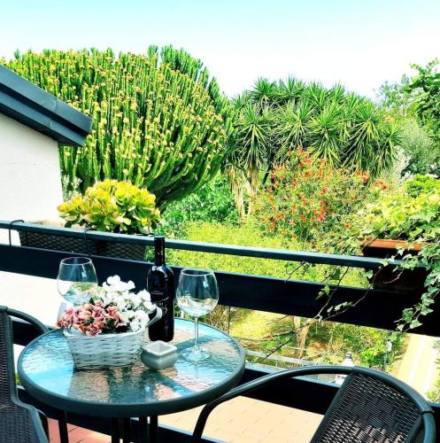 a table with two wine glasses and a basket of flowers at Grotta dei Puntali B&B in Carini