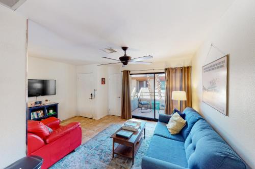 a living room with a blue couch and red couches at Kitschy Rich Palm Springs Permit #60096 in Palm Springs