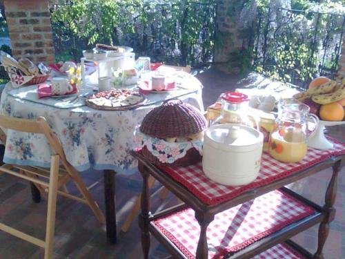 una mesa de picnic con una mesa con comida y bebidas. en B&B I Cherubini, en Cislago