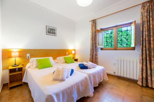 two twin beds in a room with a window at Villa Can Joan den Coves in Santa Gertrudis de Fruitera