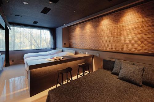 a bedroom with a bed and a desk with two stools at River Retreat Garaku in Toyama