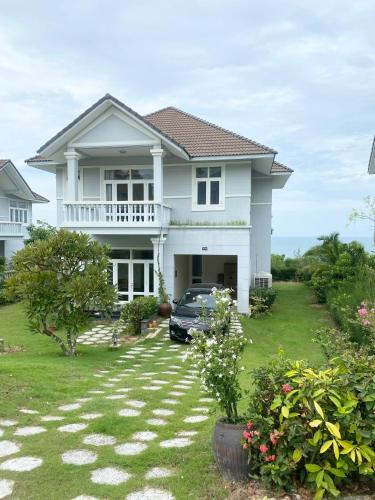 a house with a car parked in the yard at Villa Sea Links ( Biệt Thự nghỉ dưỡng ) in Ấp Phú Tịnh (2)