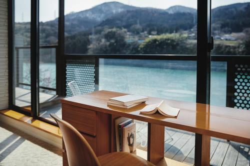 a desk in a room with a large window at River Retreat Garaku in Toyama