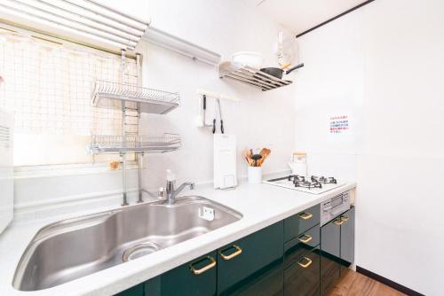 a kitchen with a sink and green cabinets at Ikebukuro Max14ppl 6bedrooms 11beds 1200sqft in Tokyo