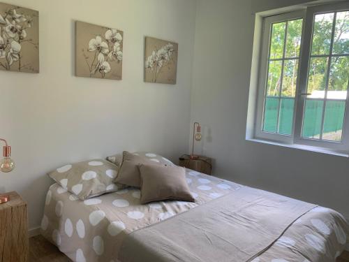 - un lit dans une chambre avec 3 photos sur le mur dans l'établissement joli logement indépendant, à Mont-près-Chambord