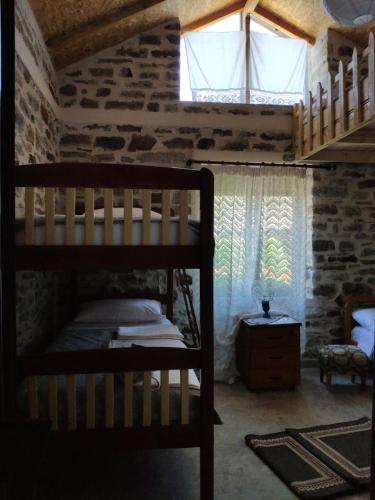 a bedroom with a bunk bed and a window at Stone House in Këlcyrë