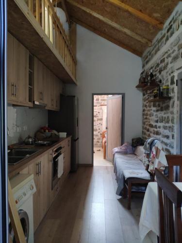 una cocina con armarios de madera y una mesa en una habitación en Stone House en Këlcyrë