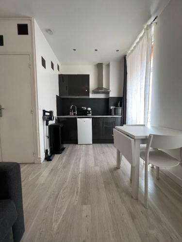 Il comprend un salon avec une table blanche et une cuisine. dans l'établissement Central location near the Sacré-Coeur, à Paris
