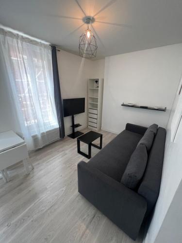 - un salon avec un canapé noir et un piano dans l'établissement Central location near the Sacré-Coeur, à Paris