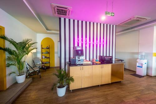 an office with a pink ceiling and two potted plants at Olive Indiranagar - By Embassy Group in Bangalore