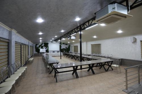 a conference room with tables and chairs and a whiteboard at CHlNOR HOTEL in Andijan