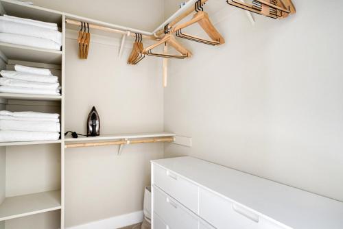 a closet with white walls and wooden hangers at San Mateo 2BR w Pool Gym easy highway access SFO-713 in Foster City