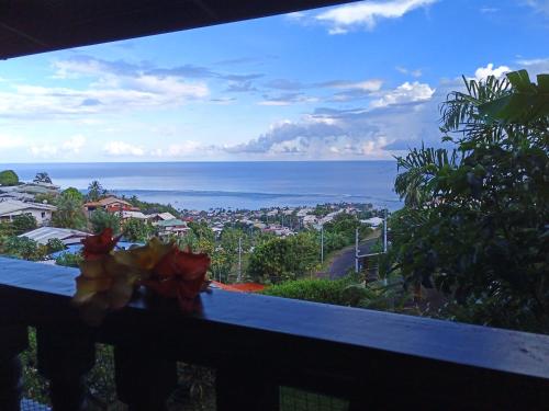 a view of the ocean from a balcony at Enzo lodge chambre tipanier in Papawa