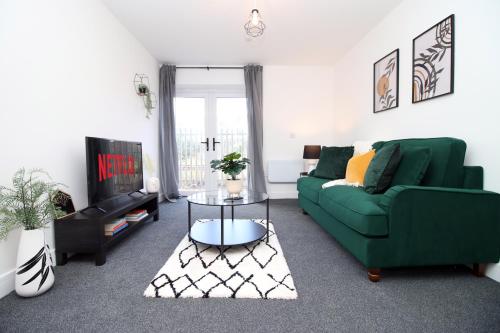 a living room with a green couch and a tv at New Modern 1 Bedroom Apartments - Prime Location - By EKLIVING LUXE Short Lets & Serviced Accommodation - Cardiff in Cardiff