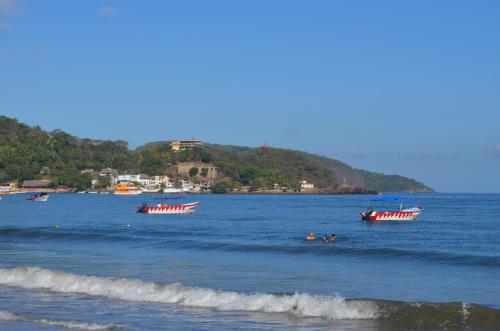 three boats in the ocean with people in the water at Bungalows Maria Teresa in Rincon de Guayabitos
