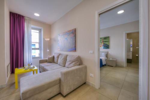 sala de estar con sofá y mesa en Palazzo dei Delfini Apartments - Happy Rentals, en Catania