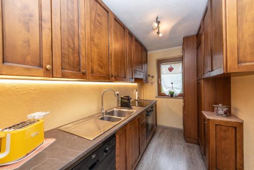 a kitchen with wooden cabinets and a sink at La casa dello scoiattolo CIR COMUNALE N 20 in Gressan