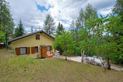 a yellow house with a table and a bench at La casa dello scoiattolo CIR COMUNALE N 20 in Gressan