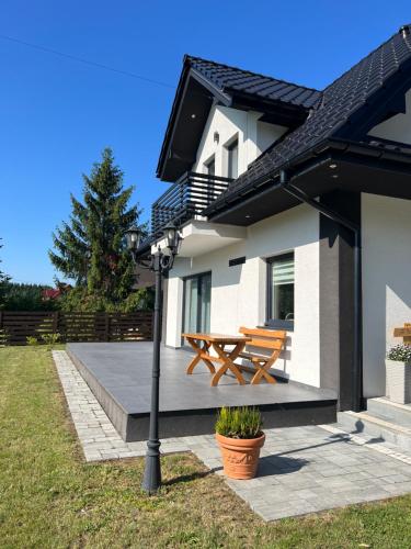 una panca di legno sul lato di una casa di Dom na Borówkowym Wzgórzu a Paleśnica