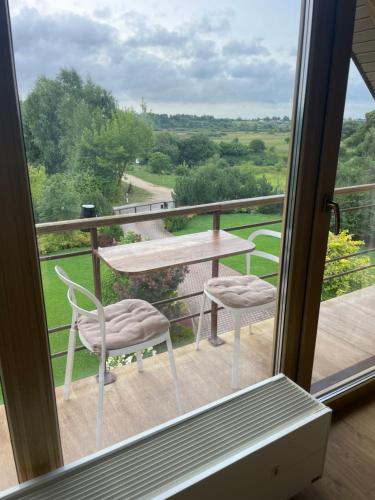a balcony with a table and chairs and a view at Comfortable apartments - Nature, silence, coziness in Kėdainiai