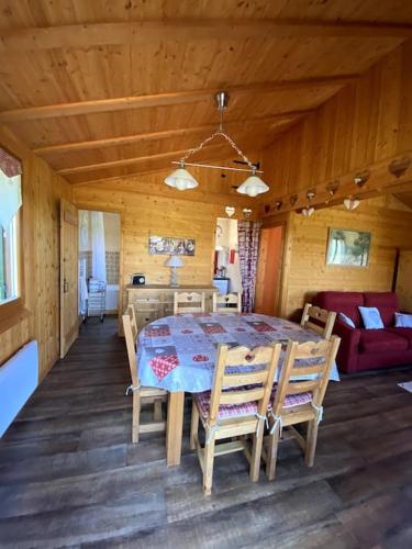 une salle à manger avec une table et des chaises dans une cabine dans l'établissement Le chalet des coeurs, à Le Tholy