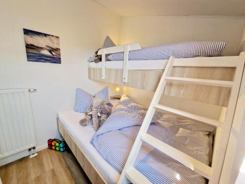 1 Schlafzimmer mit 2 Etagenbetten und einer Leiter in der Unterkunft Lotse 01 in Neustadt in Holstein