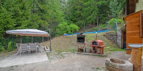 a backyard with a wood stove and a table and chairs at La casa dello scoiattolo CIR COMUNALE N 20 in Gressan