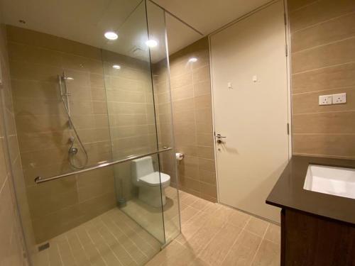 a bathroom with a shower with a toilet and a sink at By The Sea@Side Seaview n swimming pool view #133A in Batu Ferringhi