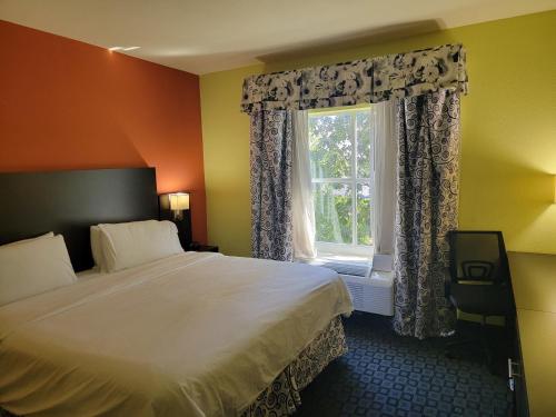 a bedroom with a bed and a window at Holiday Inn Garland, an IHG Hotel in Garland