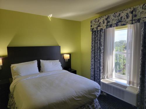 a bedroom with a large bed and a window at Holiday Inn Garland by IHG in Garland
