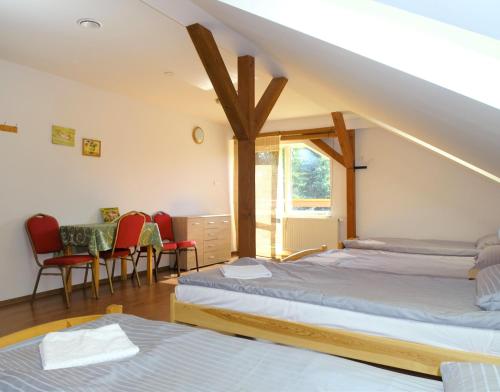 een kamer met 2 bedden en een tafel en stoelen bij Mimoza Gospodarstwo Agroturystyczne in Bartoszyce