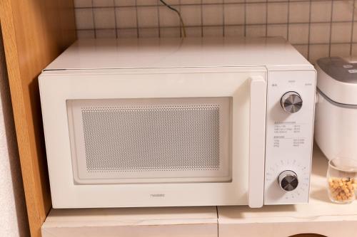 a white microwave oven sitting on a shelf at 6BR 10Beds Direct to Shinjuku, Shibuya ,Tokyo Dome, Central ,Budget Friendly in Tokyo