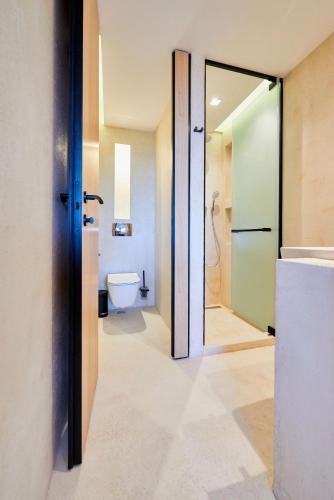 a bathroom with a toilet and a glass door at Hotel Fara - Marina Cape in Aheloy