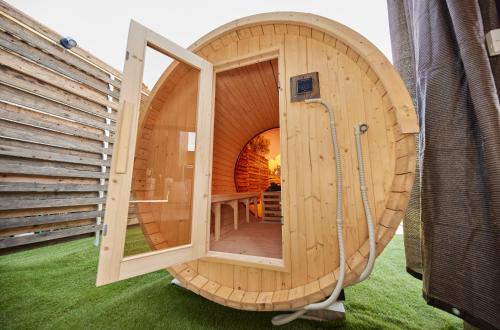 a circular wooden sauna with a shower in a house at Resoreat Takashima in Imazu