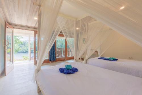 a bedroom with two beds and a window at Thalassa Dive Resort Lembeh in Airtembago