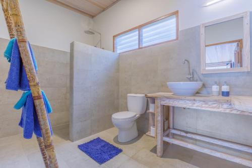 a bathroom with a toilet and a sink at Thalassa Dive Resort Lembeh in Airtembago