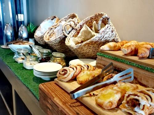 a table with bread and baskets and pastries on it at Protea Hotel by Marriott Bloemfontein in Bloemfontein
