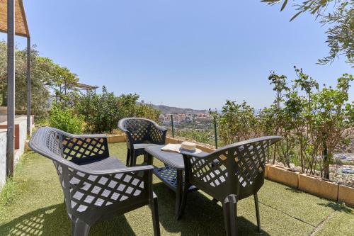 three chairs and a table on a patio at Villa Torrox Costa con Piscina in Torrox