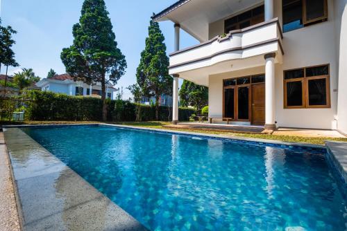 - une piscine en face d'une maison dans l'établissement Andaru Graha Puspa For Family and Friends, à Bandung