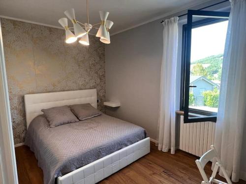 appartamento con vista collina Fornovo di Taro في Piantonia: غرفة نوم بسرير ونافذة