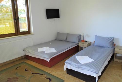 a bedroom with two beds and a tv on the wall at Mimoza Gospodarstwo Agroturystyczne in Bartoszyce