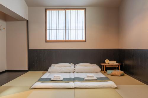 a bedroom with a large bed with towels on it at Irodori Hotel SORA in Fukuoka