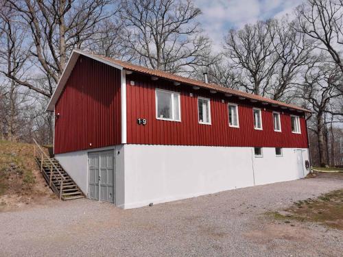 a red and white building with a garage at Marsbäckens lägergård in Västervik