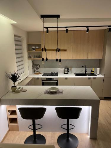 a kitchen with a large island with two bar stools at Apartments Stećak in Sarajevo