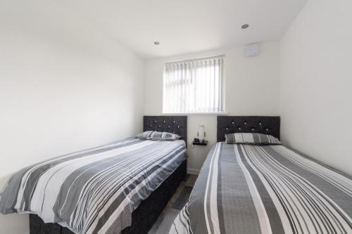 2 letti in una camera con pareti bianche di 2 bedroom luxury beach apartment Millendreath a Saint Martin