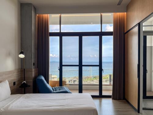 a bedroom with a bed and a view of the ocean at 緩慢大鵬灣 in Donggang