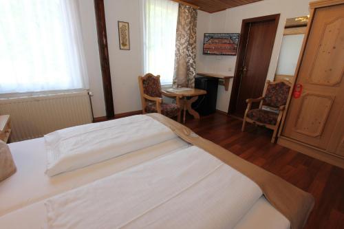 a bedroom with a bed and a table and chairs at Hotel "Glück Auf " in Bad Grund