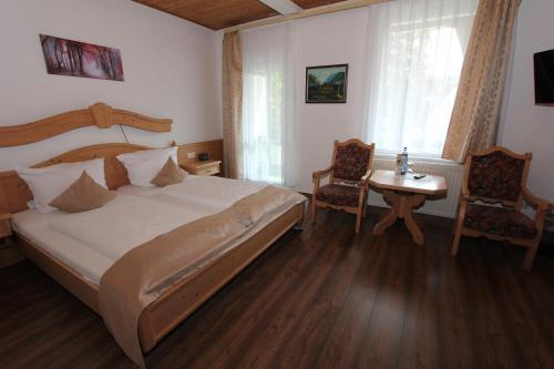 Schlafzimmer mit einem Bett, einem Tisch und Stühlen in der Unterkunft Hotel Glück Auf & Bürgerkeller in Bad Grund