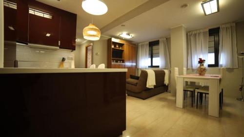 een keuken en een woonkamer met een bank en een tafel bij Apartamento Estadio Tartiere in Oviedo