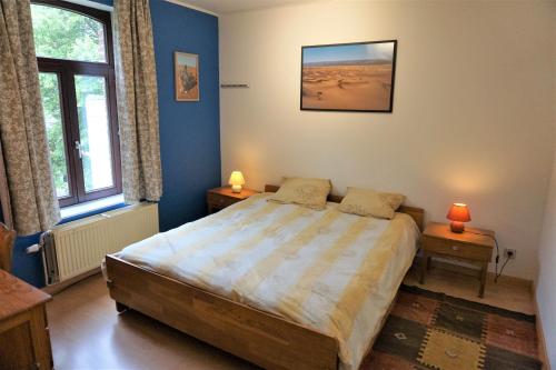 a bedroom with a large bed and two windows at Au Randonneur - B&B in Thuin